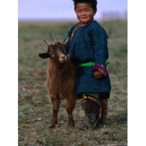 Boy Wearing Traditional Dell Standing Next to Baby Goat, Mongolia 