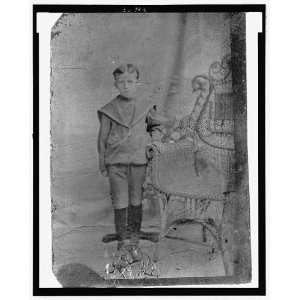   of a young boy next to a wicker chair,1907,Tintype